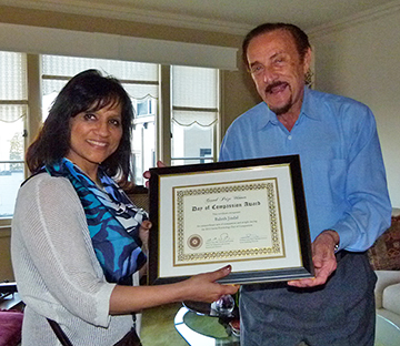 Balesh Jindal of New Delhi, India, a student in the Social Psychology MOOC, holds up her Day of Compassion Award with Stanford University Professor Emeritus Philip Zimbardo, a contributor to the MOOC. Jindal was the winner of a contest that asked students to live 24 hours ascompassionately as possible, and analyze the experience through a social psychology lens.
