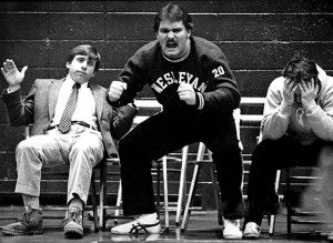 In this photo from his undergraduate days, wrestler Mike Whalen ’83 is fierce in encouraging his teammates; Coach John Biddiscombe (left) displays a calmer demeanor.  