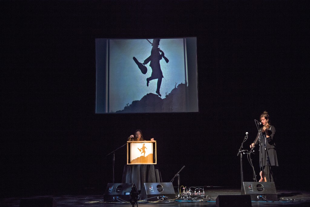 Anna Roberts-Gevalt ’09 plays the fiddle while Elizabeth LaPrelle works the “crankie.” A scrolling shadow puppet show, the crankie allows “the audience to feel that ... magical thing that we feel when we experience the music,” says Roberts-Gevalt. 