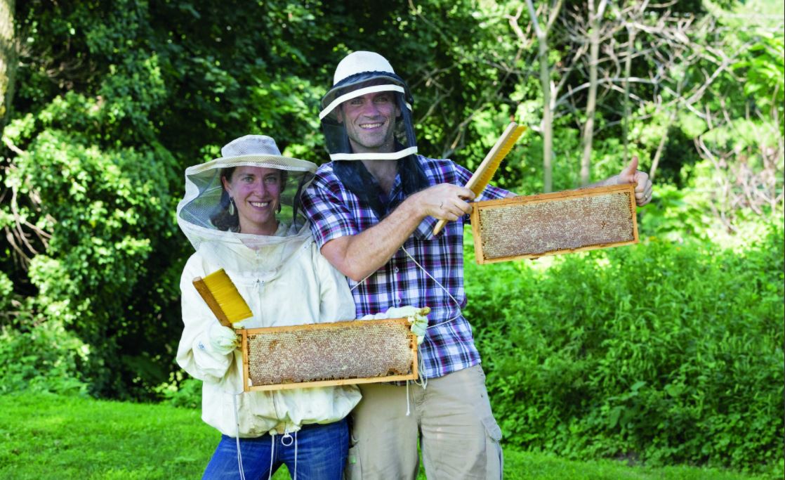 Beekeeper-herablist-artist Stephanie Bruneau '00 (here, with her husband, Emile), runs The Benevolent Bee, a small business selling honeybee hive-derived products.