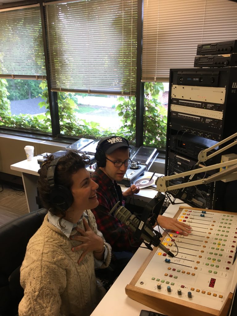 Avery Trufelman and Mickey Capper sit in the WESU studio and the sound board
